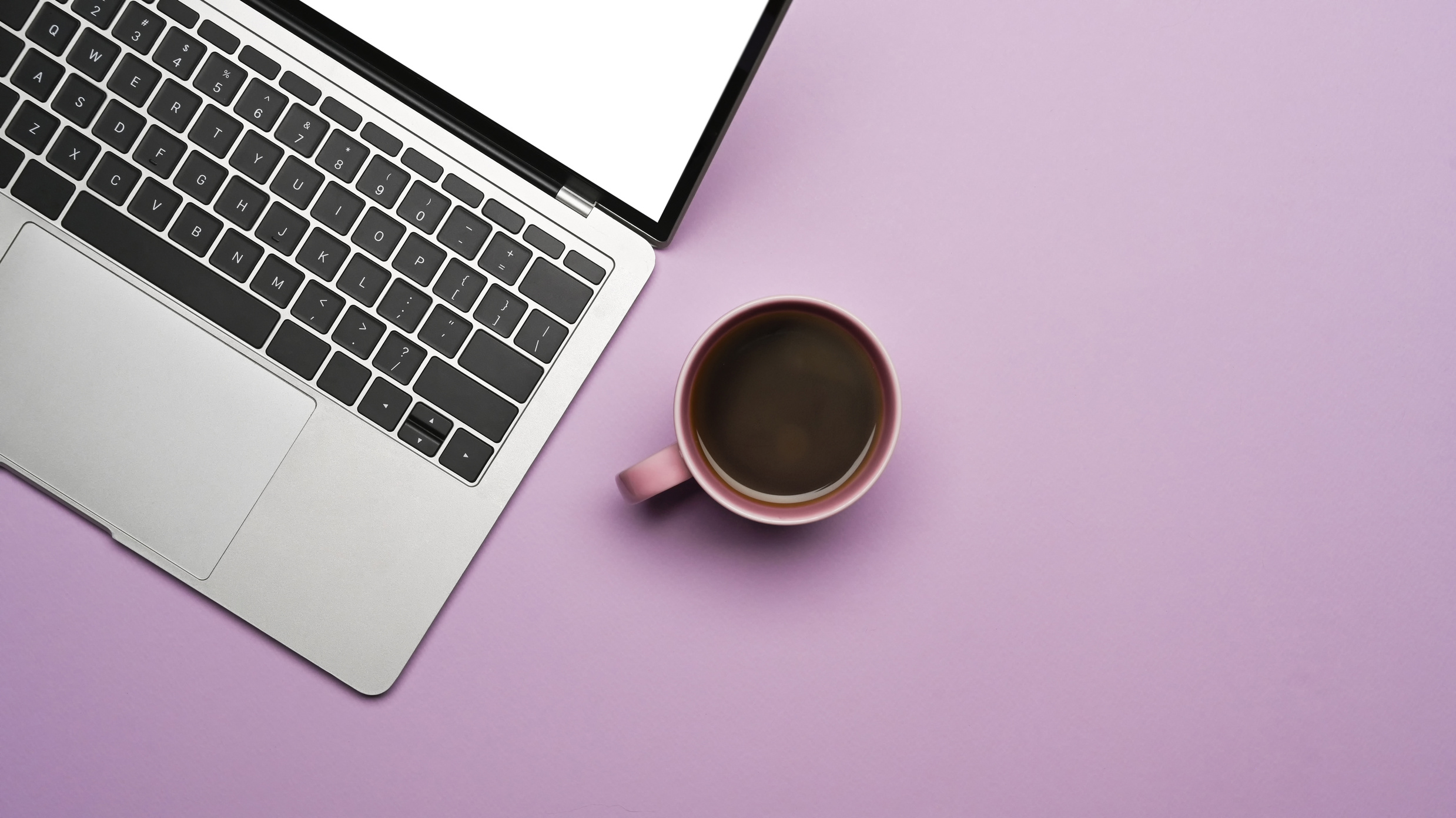 Mockup laptop computer and coffee cup on purple background.